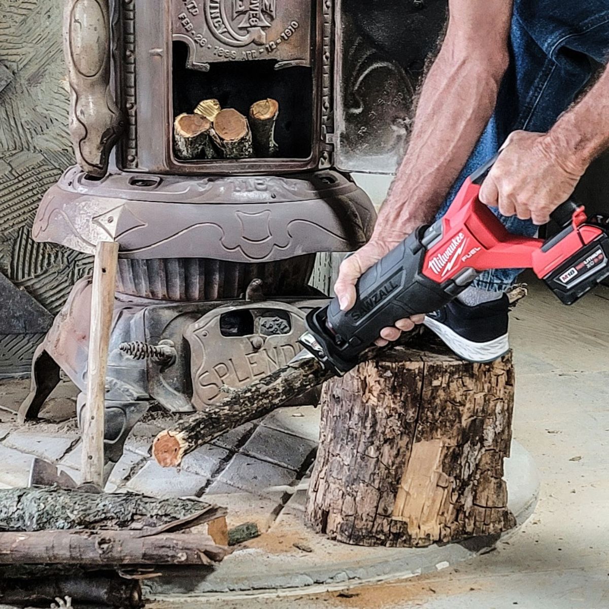 Milwaukee M18 Fuel Sawzall Reciprocating Saw cutting a log next to a wood stove
