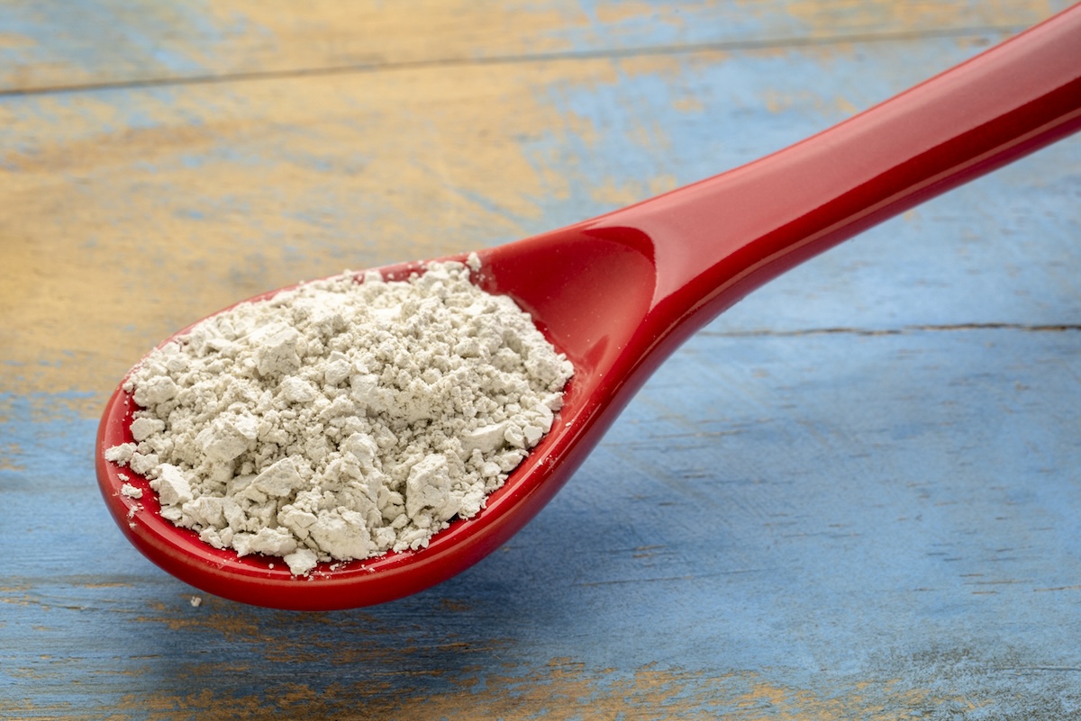 Red spoon full of diatomaceous earth.