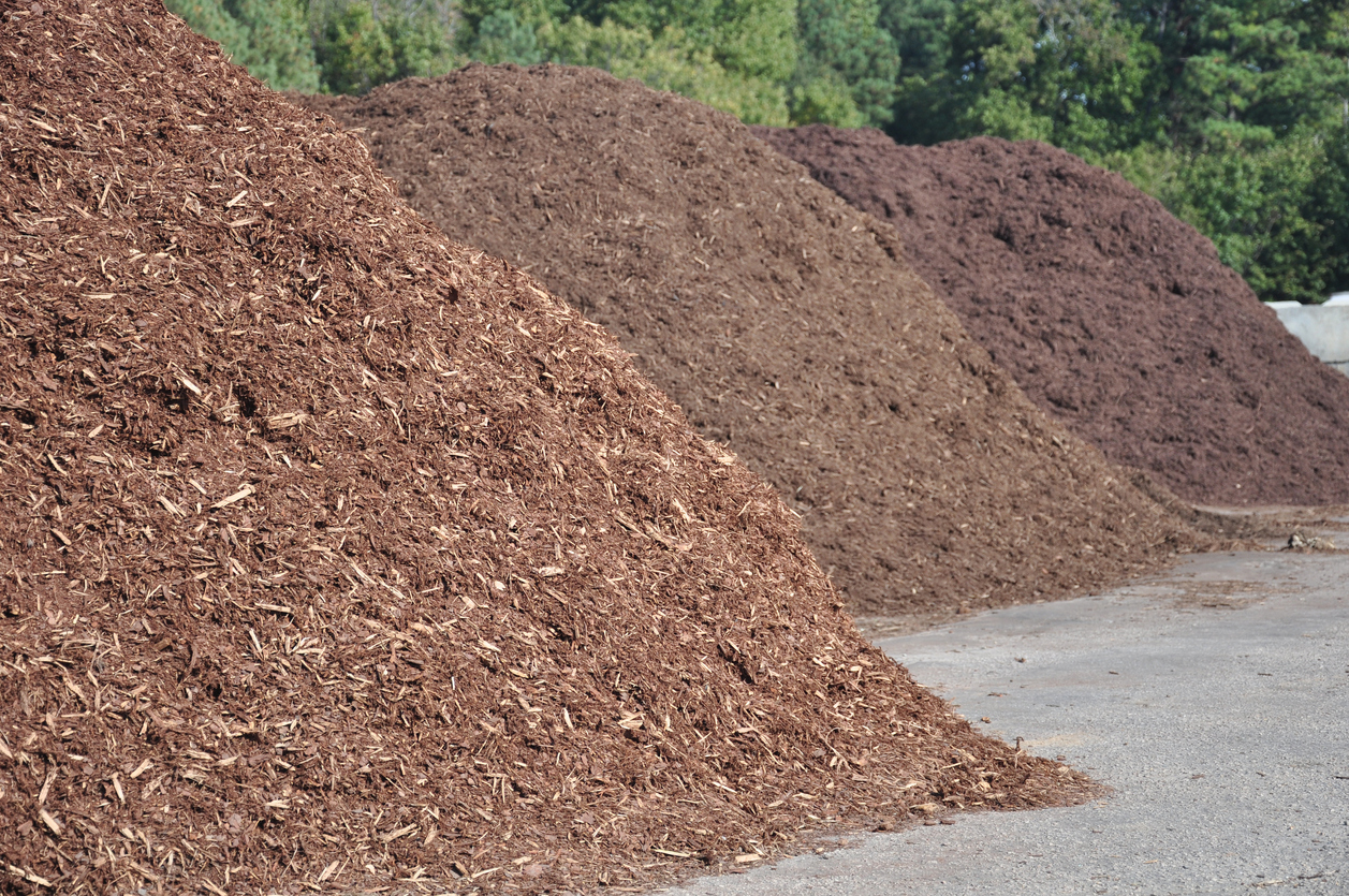 three different types of mulch offered for sale at a garden supply center
