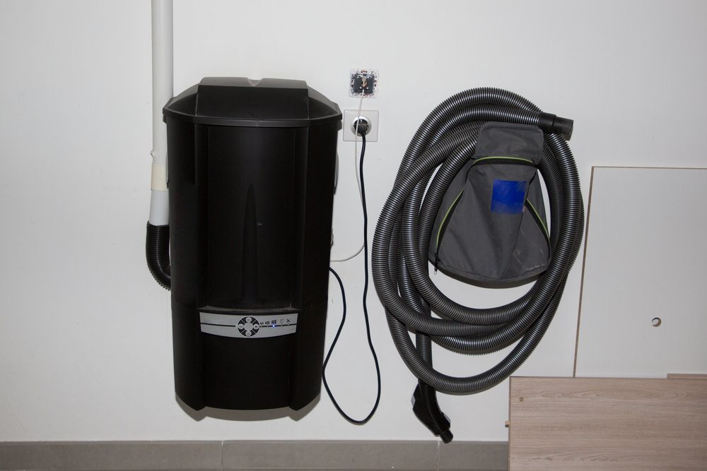 The best central-vacuum system (the canister and long hose with cleaning head) mounted on a white wall.