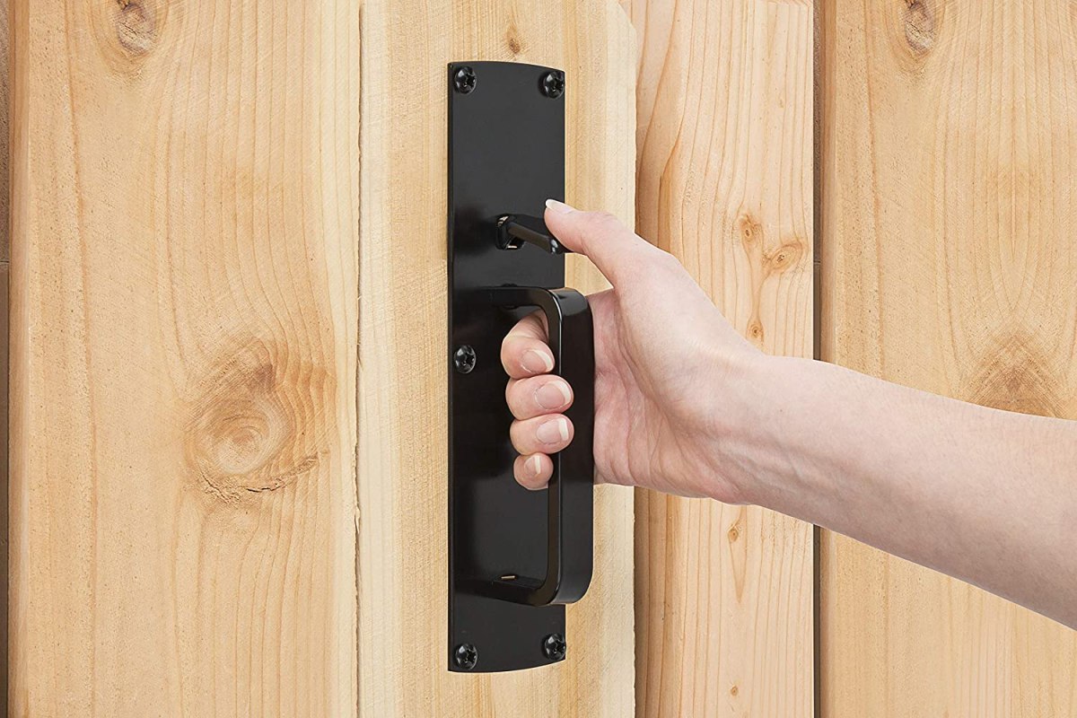 A person with their hand on the best gate latch option