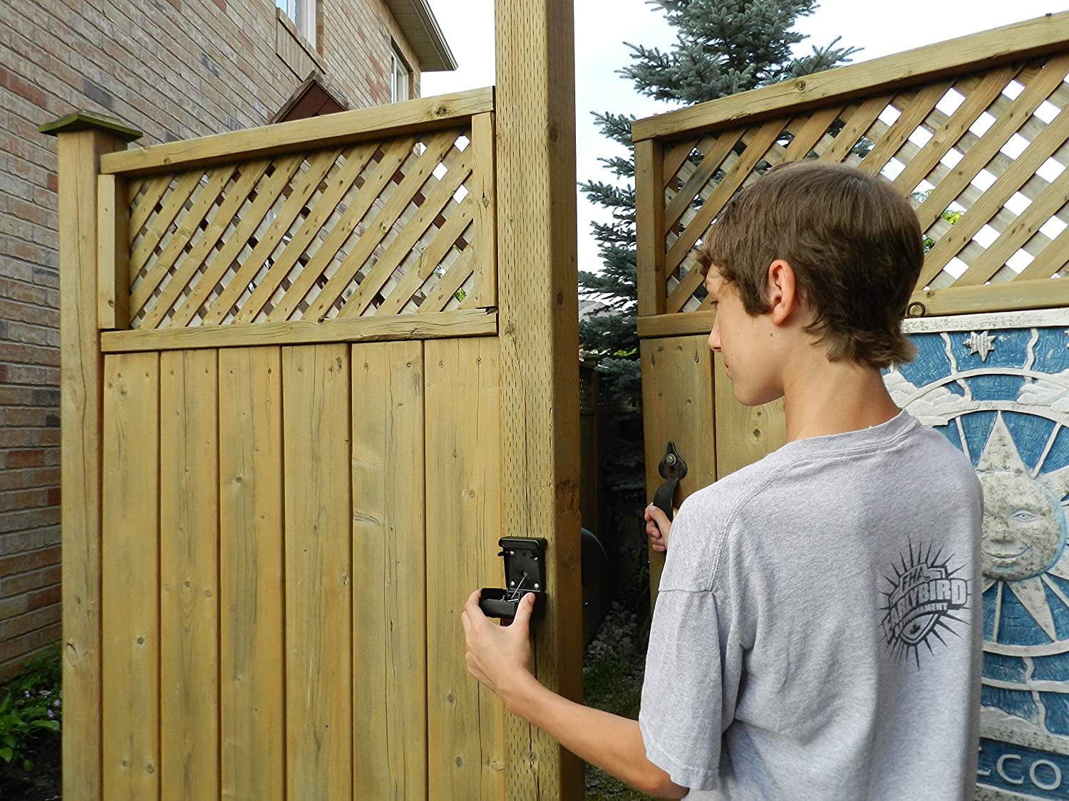 A young person using the best gate latch option to open a gate in a fence