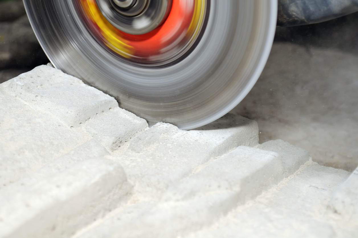 A grinder in motion cutting a concrete block