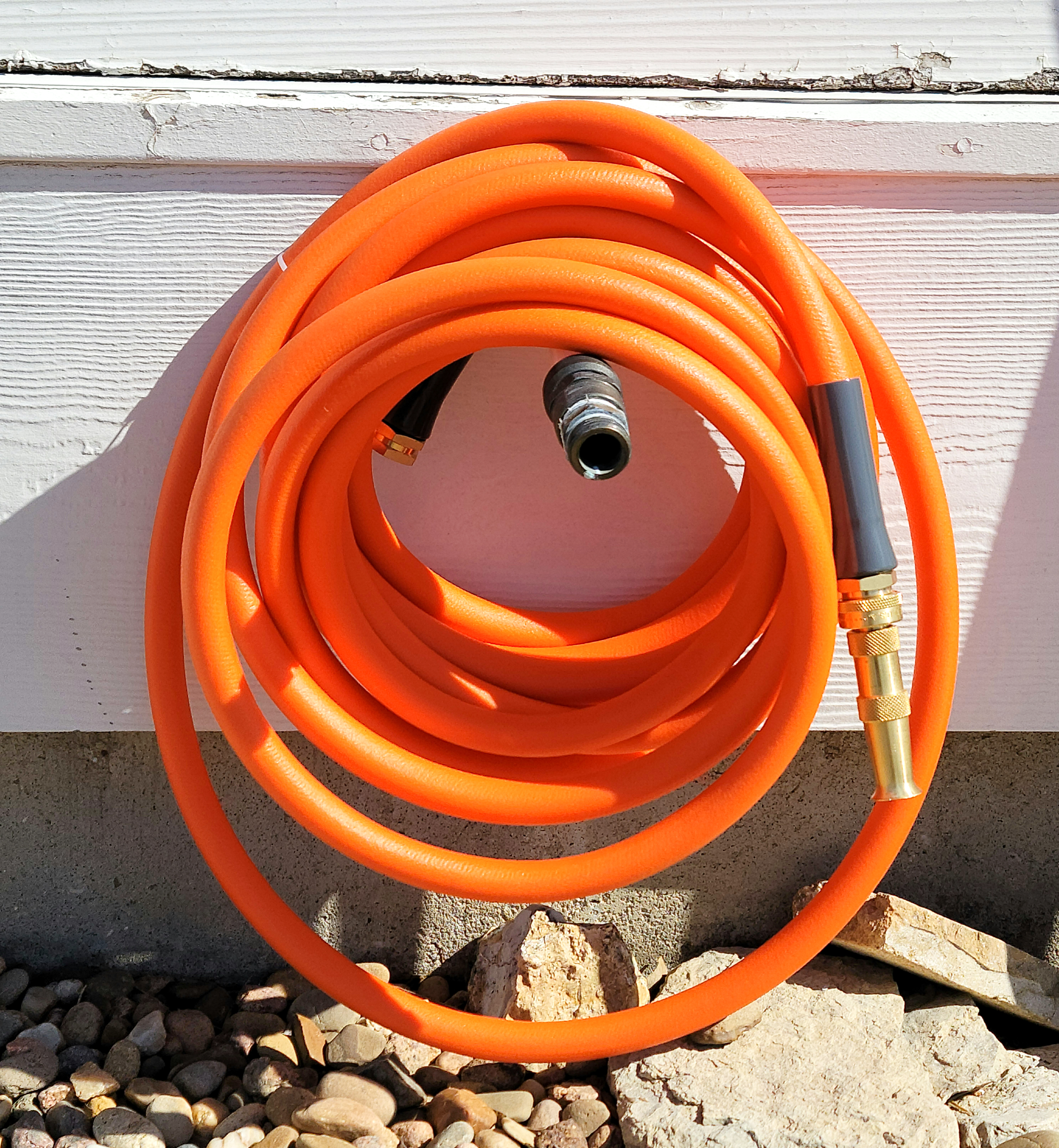Orange garden hose wrapped and stored