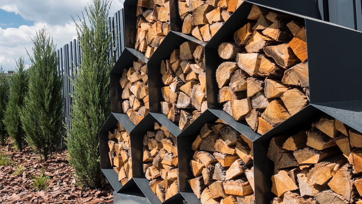 A honeycomb style firewood storage unit outside of a home.