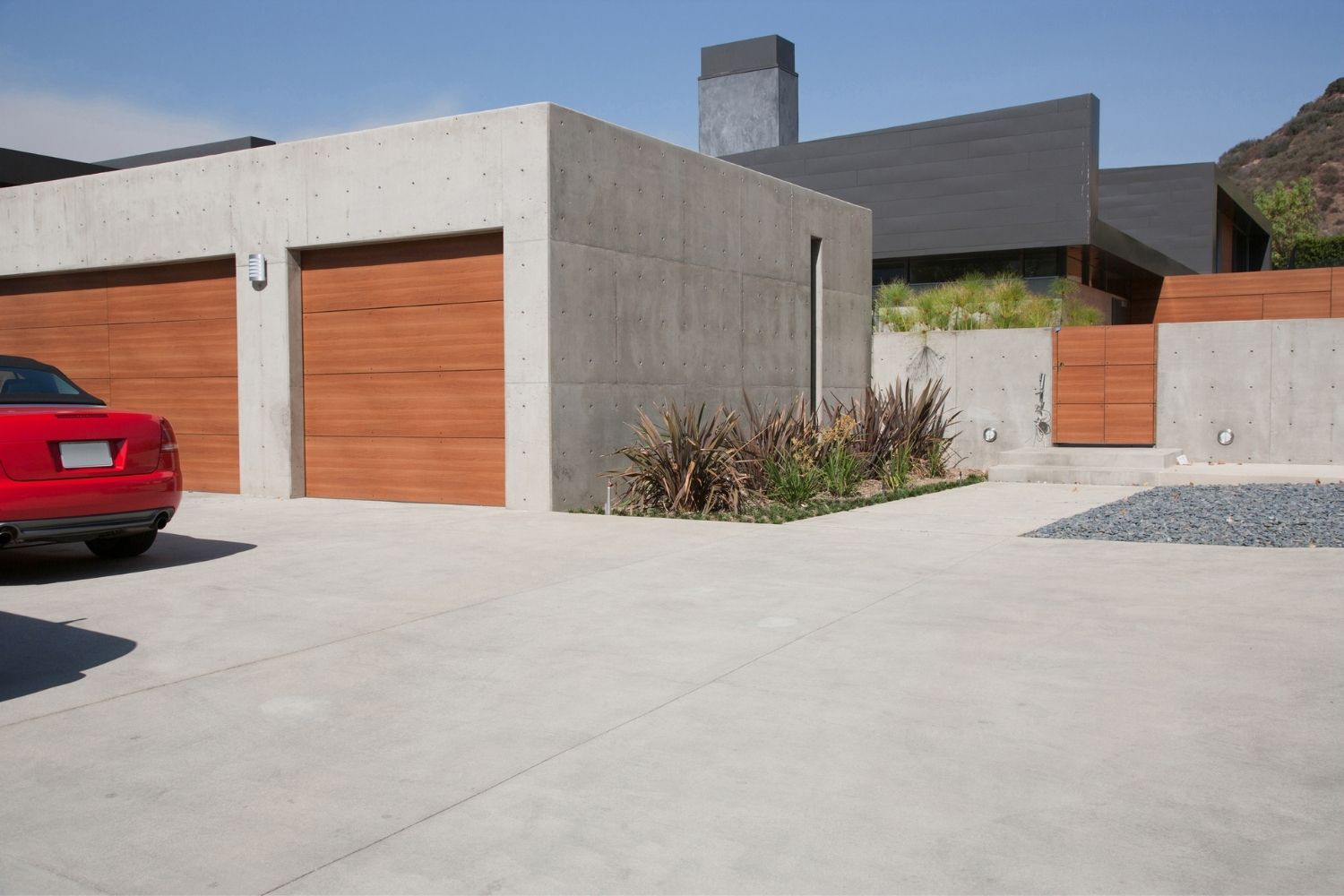 A view of a pristine concrete driveway on a sunny day.