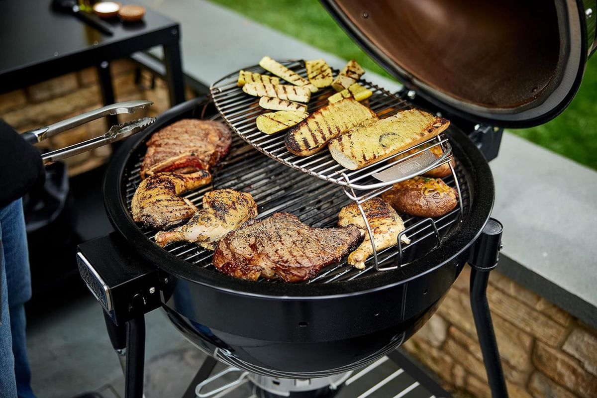 Assorted meats and vegetables cooking on the best kamado grill.