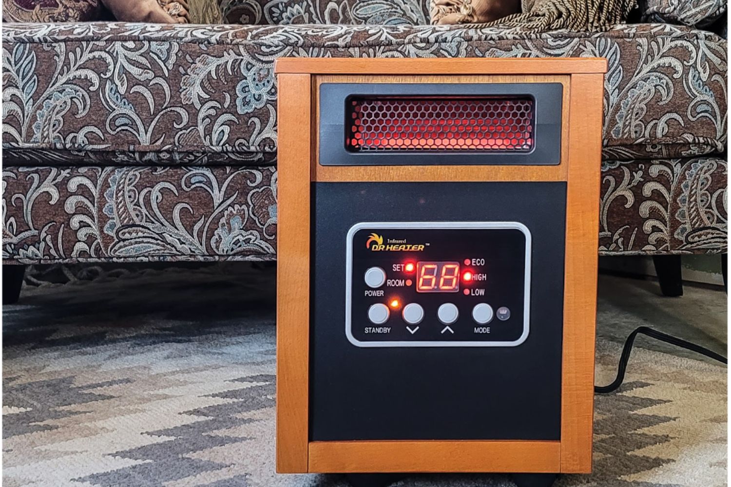 An energy-efficient space heater on a carpeted floor in front of a couch.