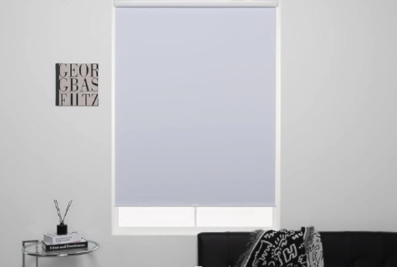White cordless blackout roller shades in living room