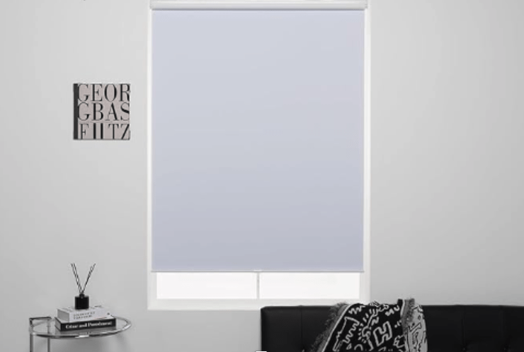 White cordless blackout roller shades in living room