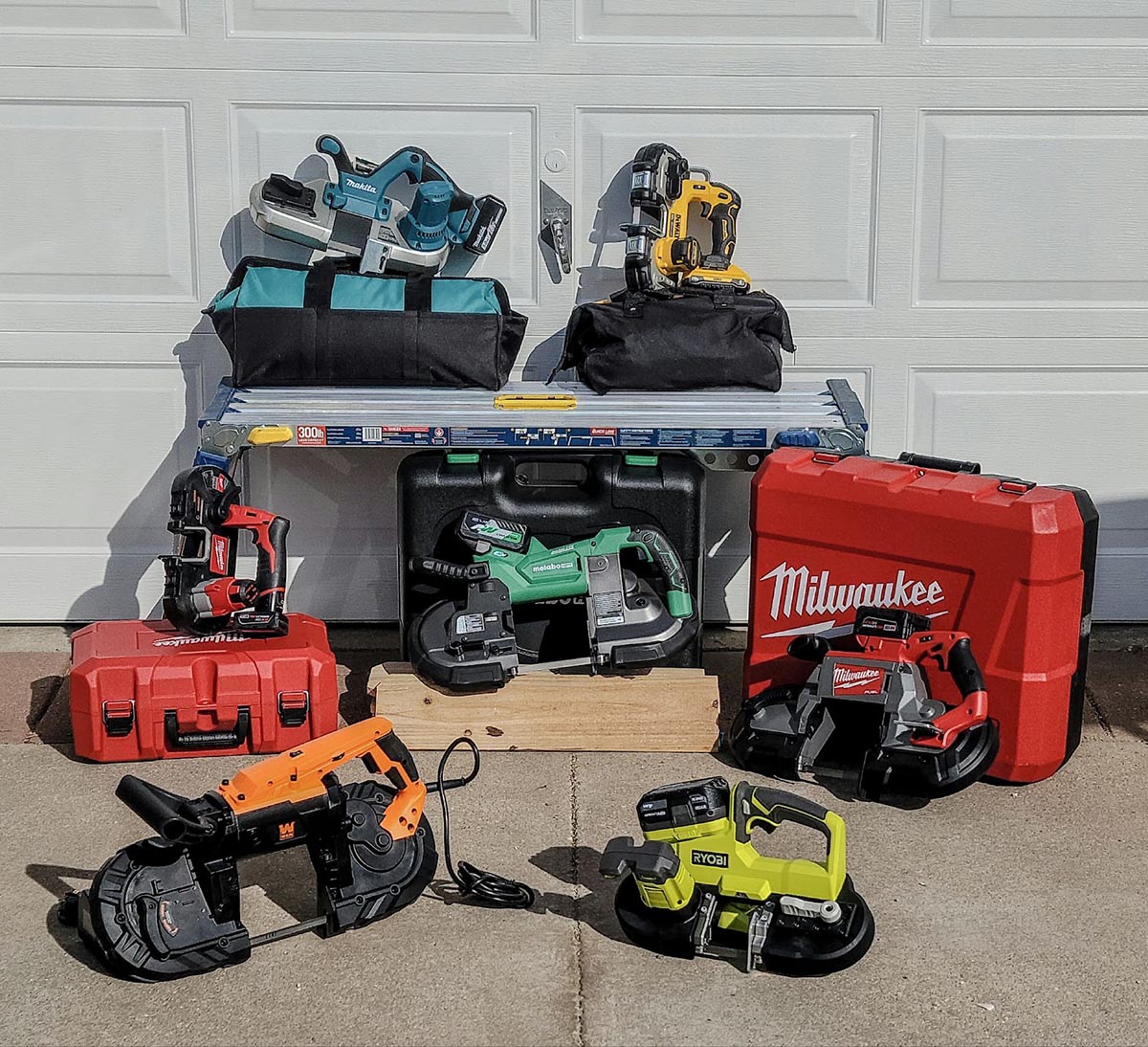 A group of the Best Portable Band Saws in front of a garage door before testing.