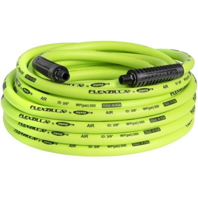 The Flexzilla ⅜-Inch 50-Foot Air Hose stretched out on the ground next to a car tire.