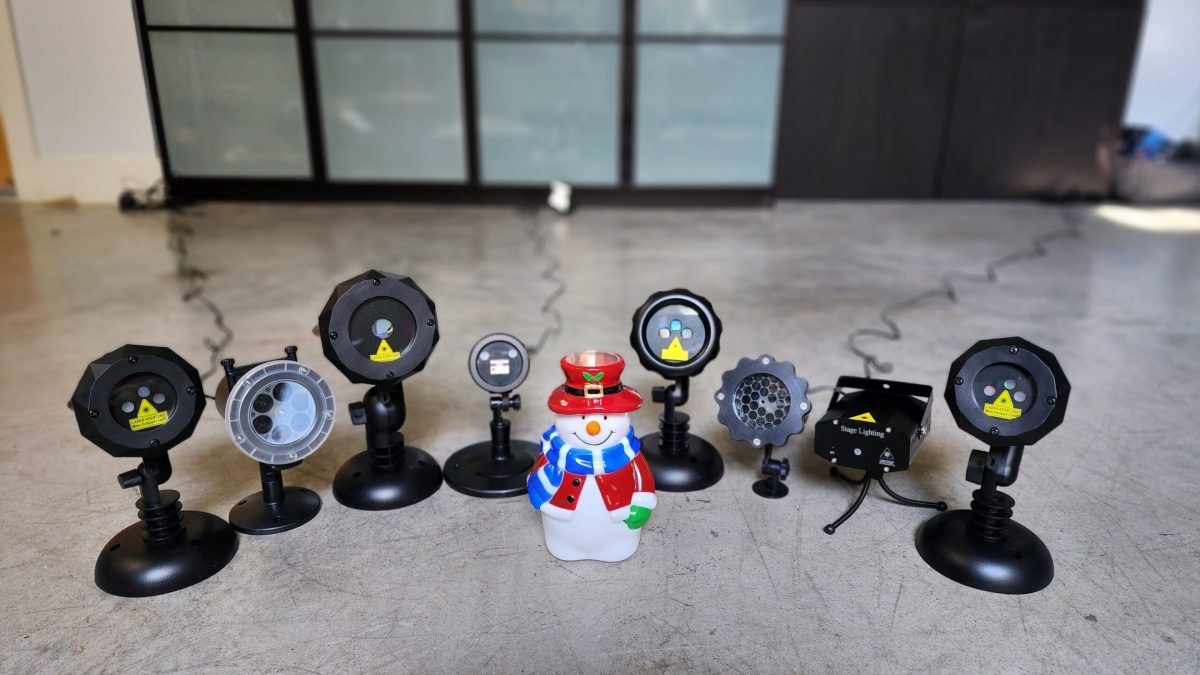 A group of the best Christmas light projectors together on a cement surface.