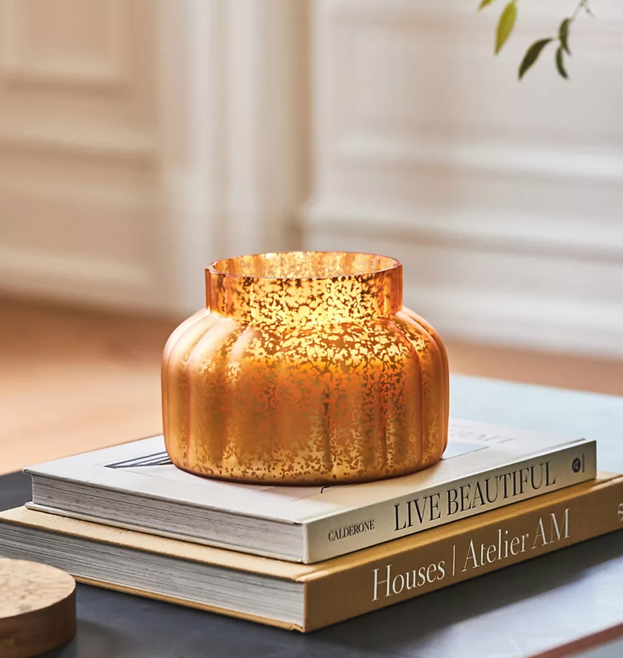 The Best Halloween Decorations: Capri Pumpkin Clove Candle on a Coffee Table of Books