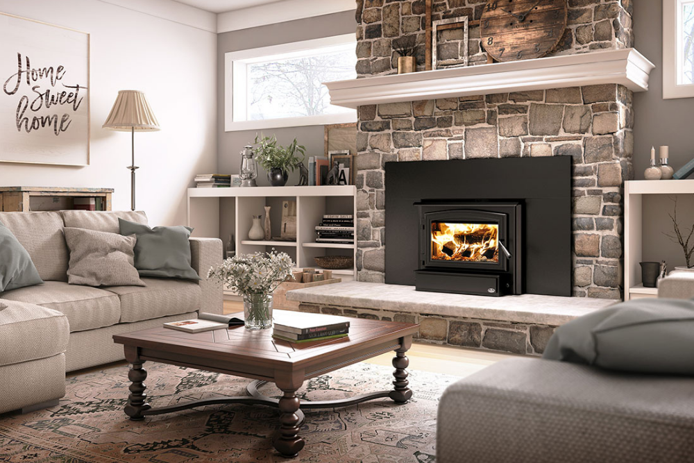 The best wood-burning fireplace inserts option set in a large stone chimney in a spacious living room