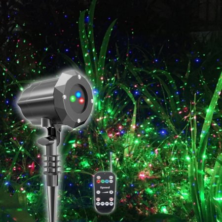  The Poeland Outdoor Christmas Projector Light and remote on a projected background of green grass with colorful spots.