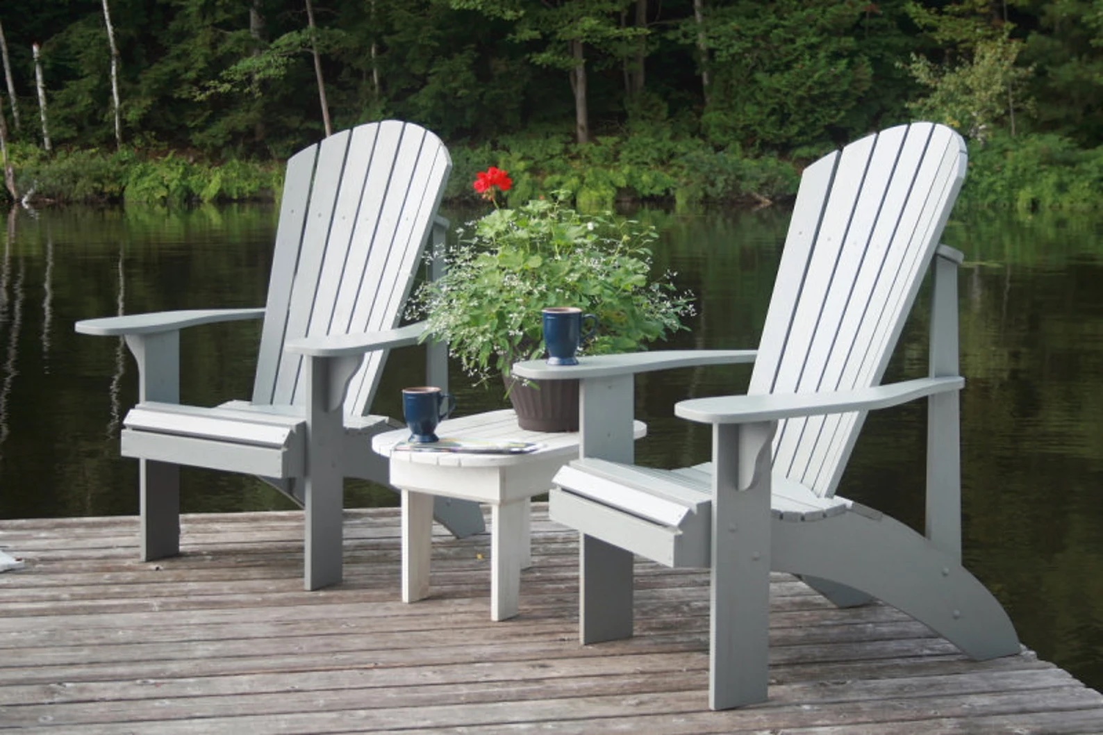 Two grey adirondack chairs on a boat deck