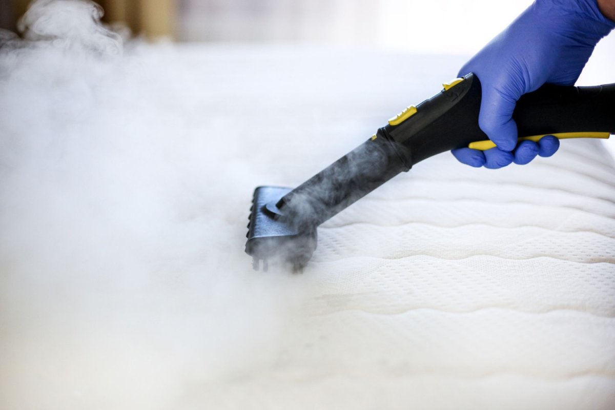 A person steaming a mattress with the best steamer for bed bugs option