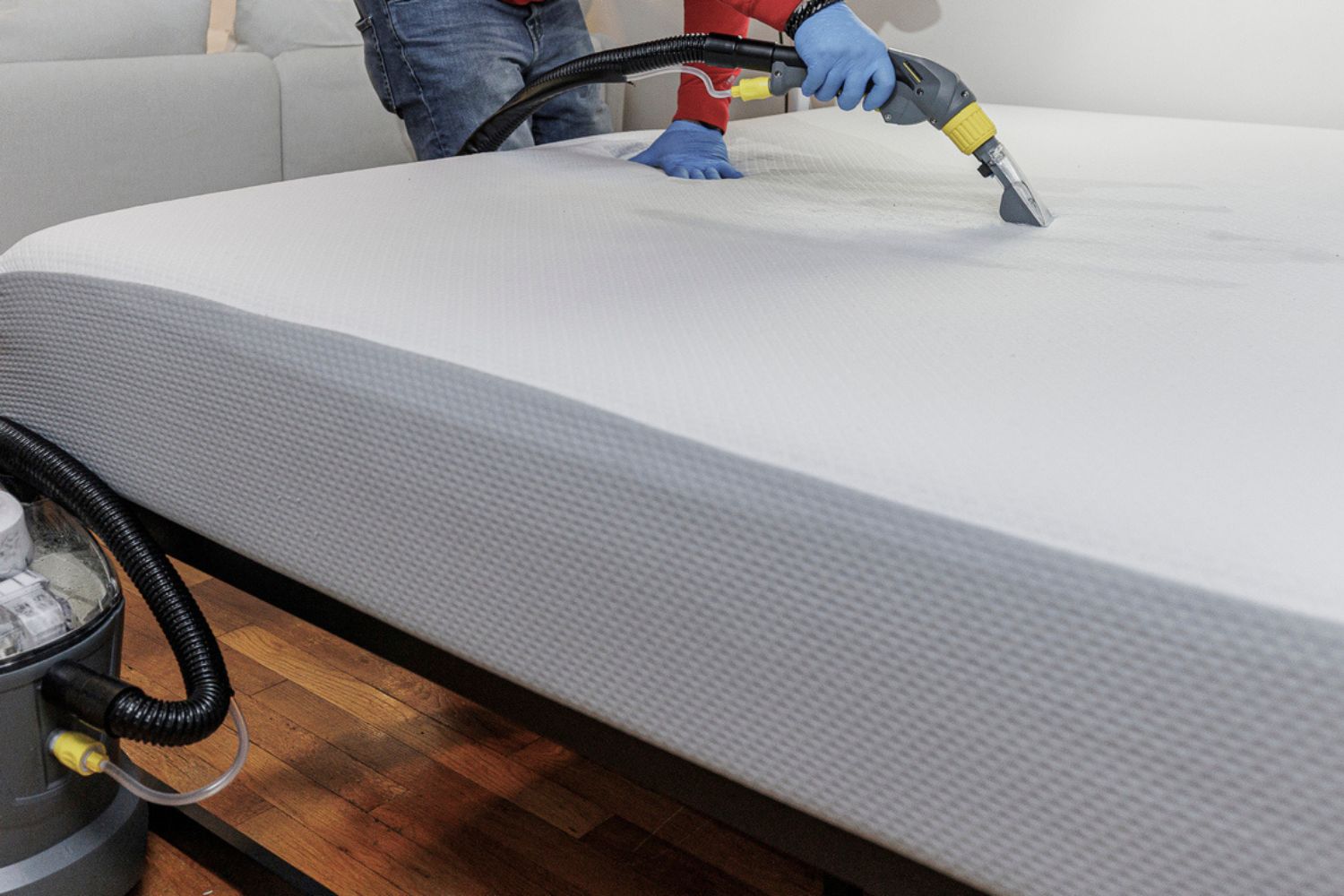 A person steaming a mattress with the best steamer for bed bugs option