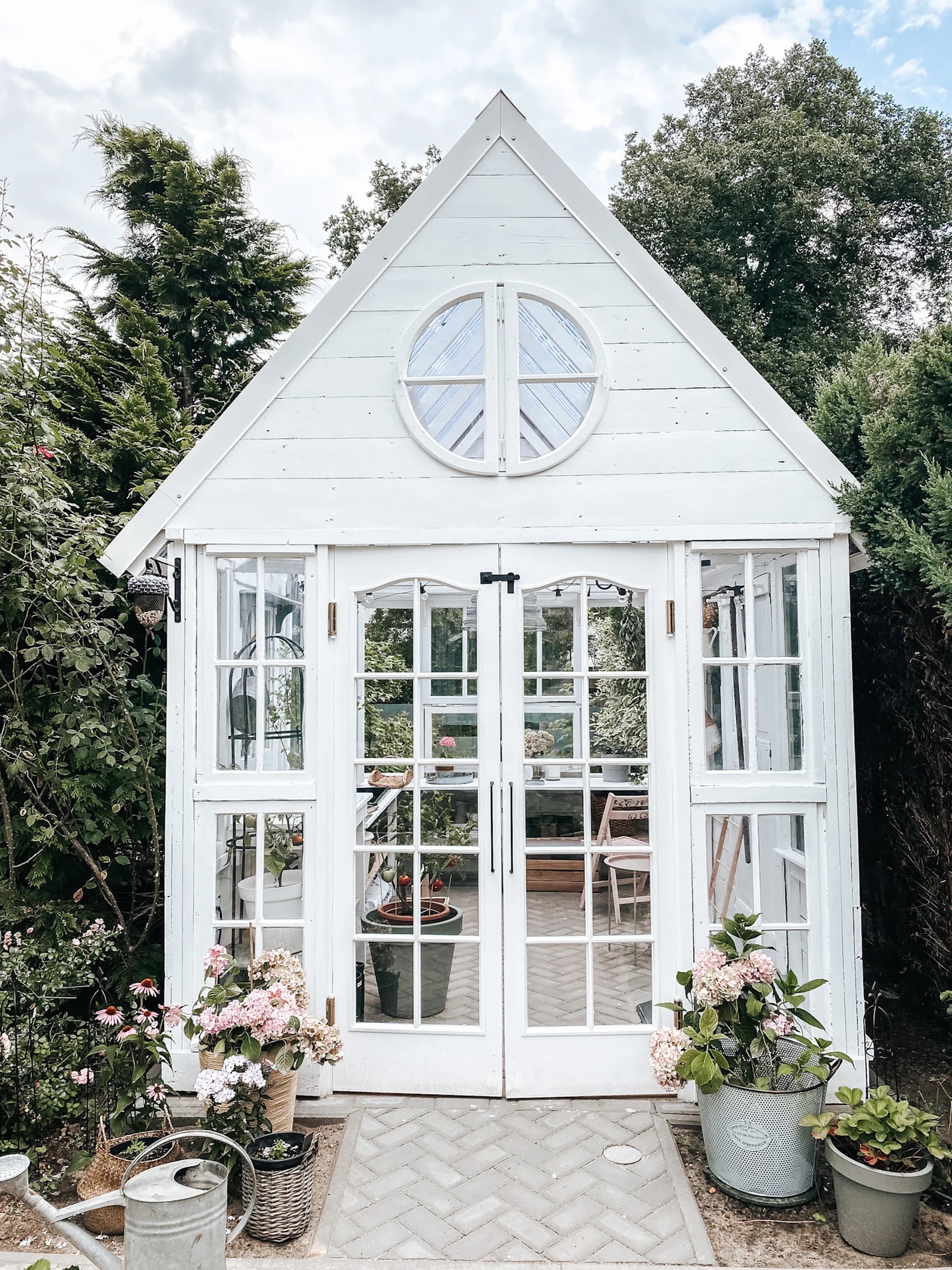 white greenhouse made out of recycled windows
