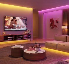 Govee string lights hung in a living room, shining in pink and gold hues.