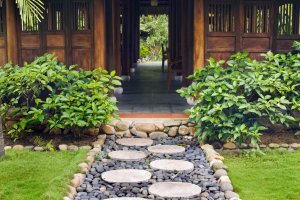 A view of a walkway made with large stepping stones leading to an outdoor building.