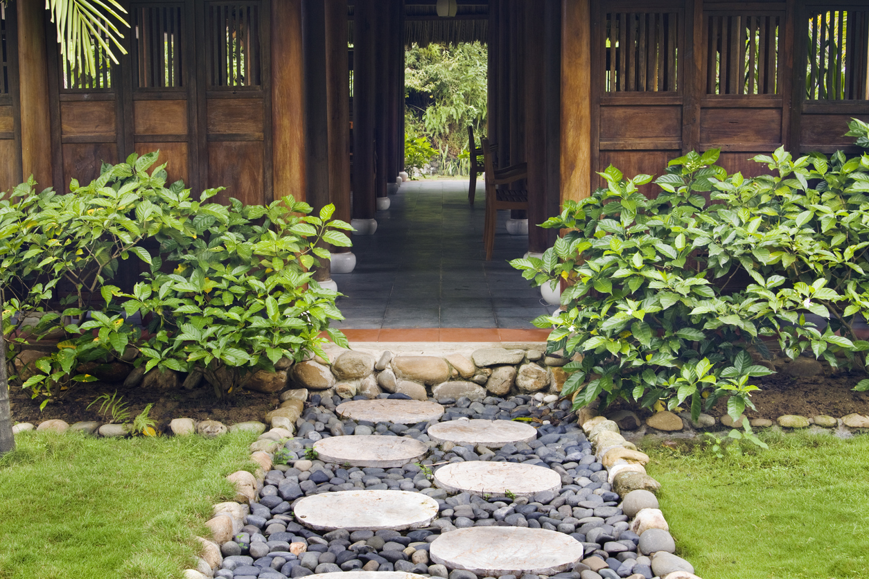 A view of a walkway made with large stepping stones leading to an outdoor building.