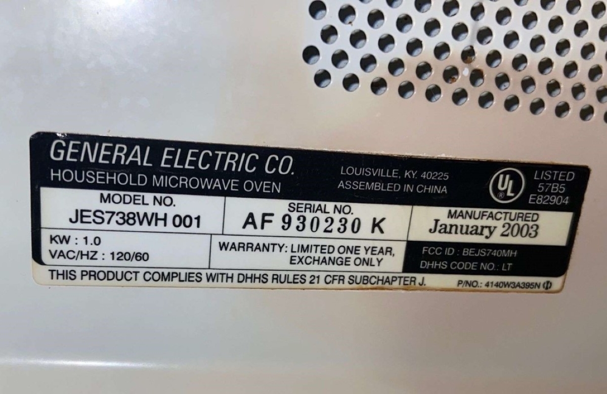 A close up of a microwave oven wattage label.