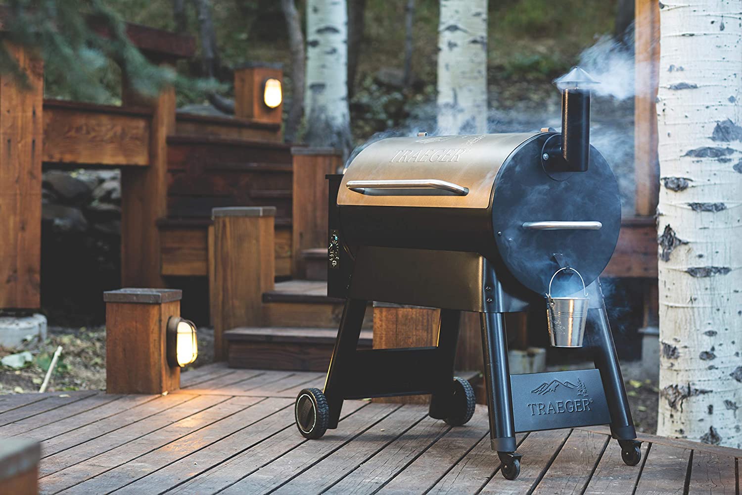 The Best Pellet Grill closed and emitting smoke on a deck at dusk