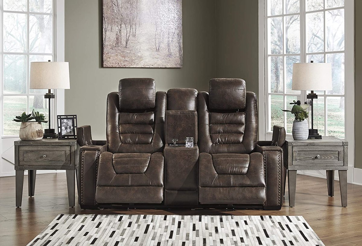 The Signature Design by Ashley Game Zone Reclining Loveseat between two end tables in a living room.