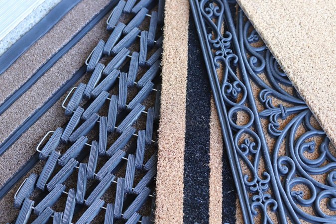 Five brown and black doormats fanned out in a display