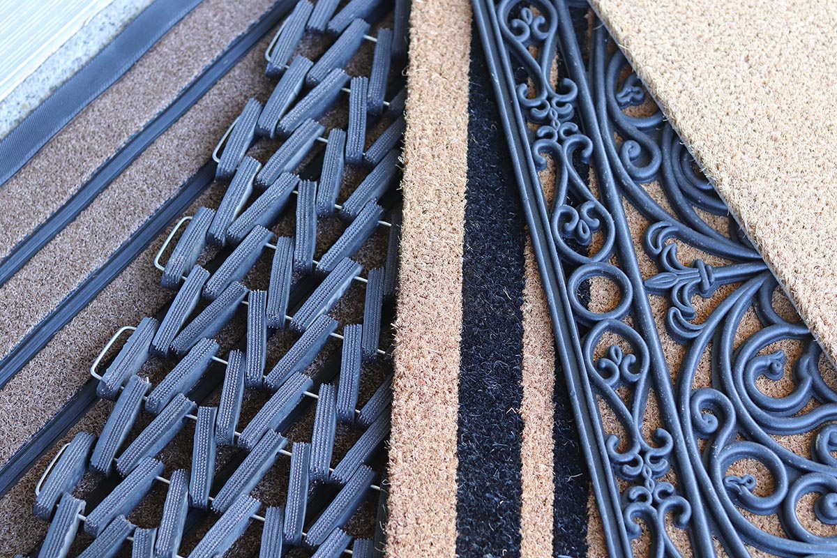 Five brown and black doormats fanned out in a display