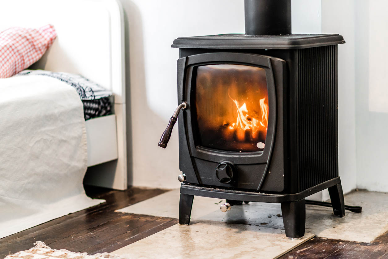 The best wood stove option burning a wood fire next to a bed
