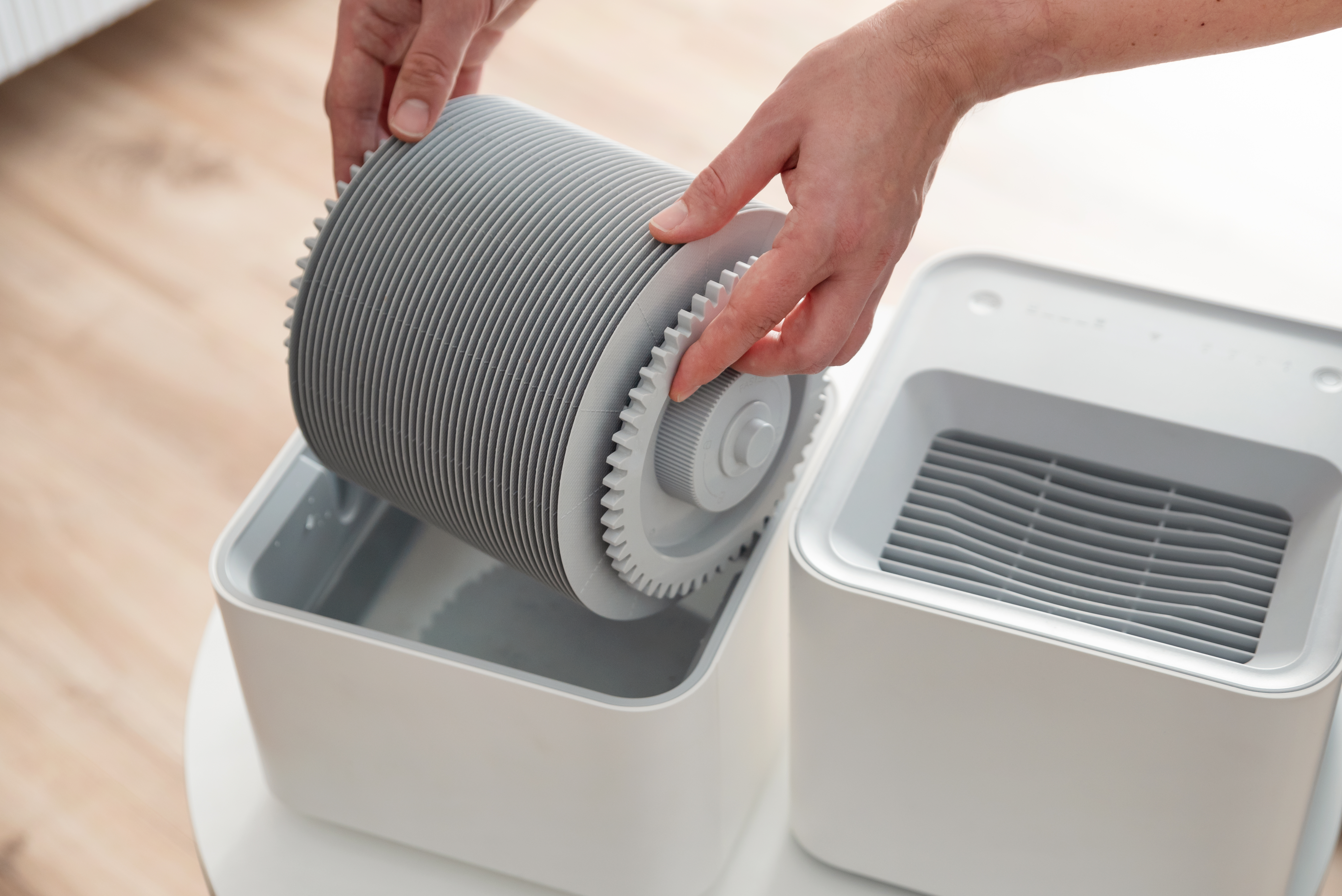 Man changing filter in humidifier in living room.