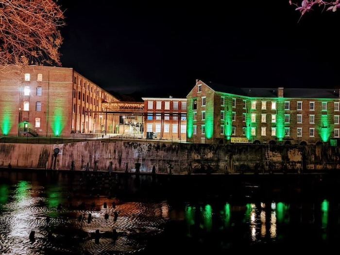The Mill at Pratville illuminated in green lights in support of U.S. veterans.