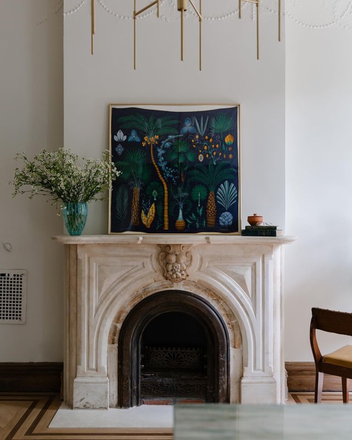 Fireplace with large painting on mantel.