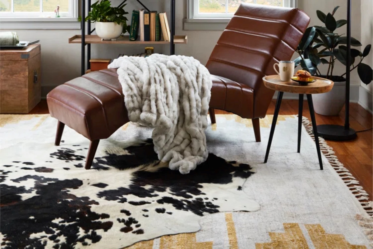Layered rugs under leather chair.