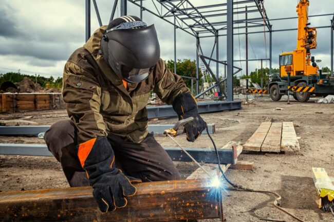 A person using welding gloves while welding