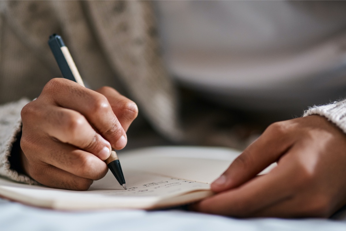 Person using a pen to write on paper.
