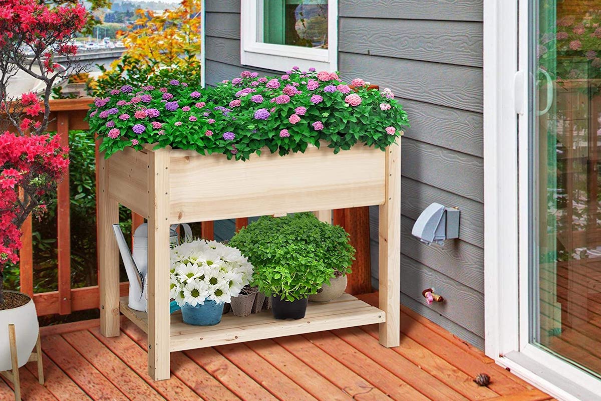 Wood two-tiered gardening cart on a deck.