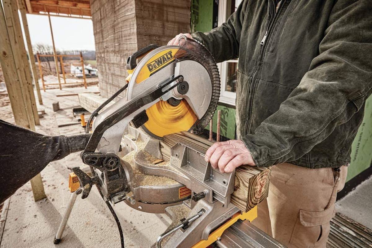 Man uses a DeWalt miter saw.