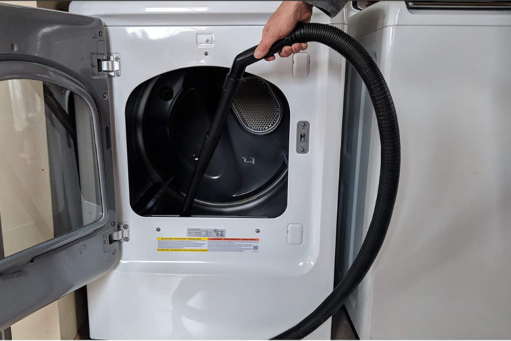 A person cleaning a dryer with the best dryer vent cleaner option