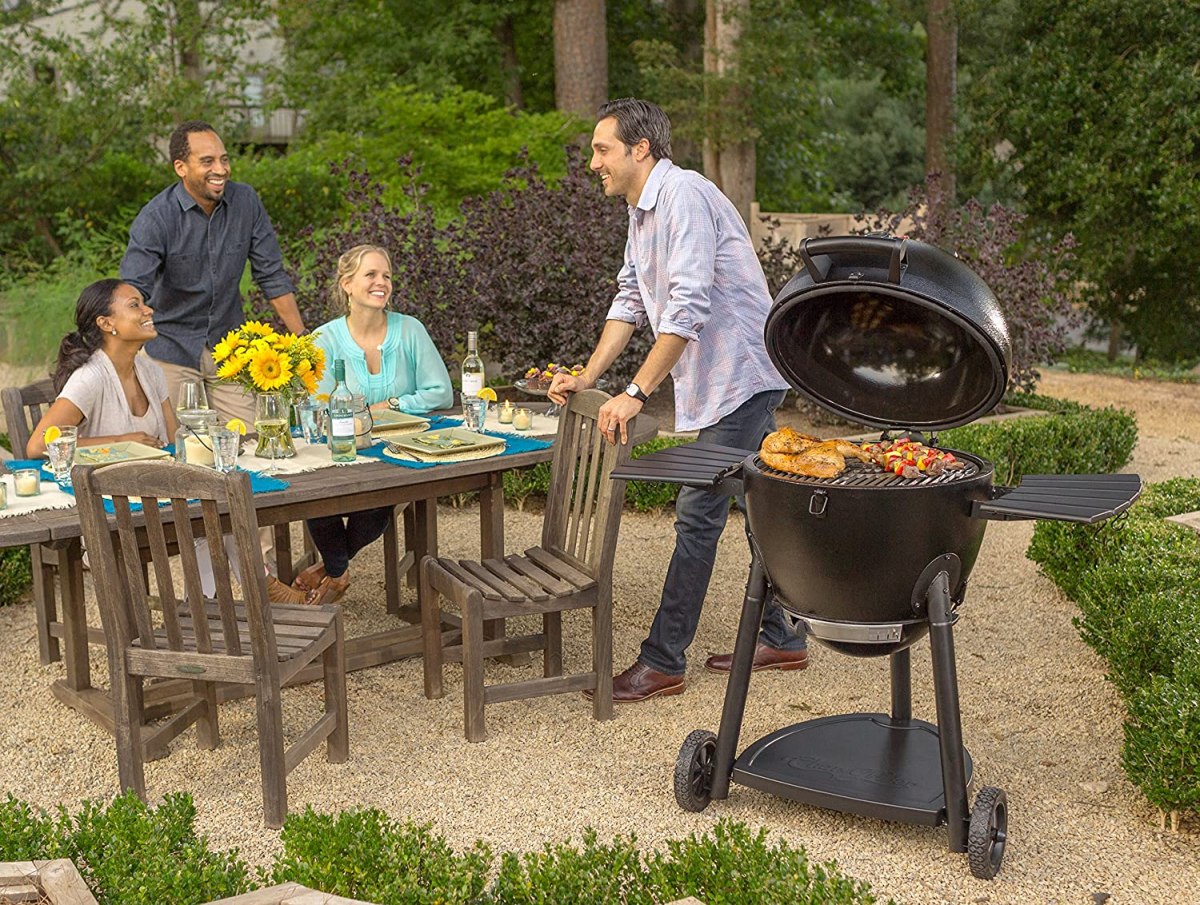 A group of friends laughing at an outdoor table next to the best smoker for beginners option