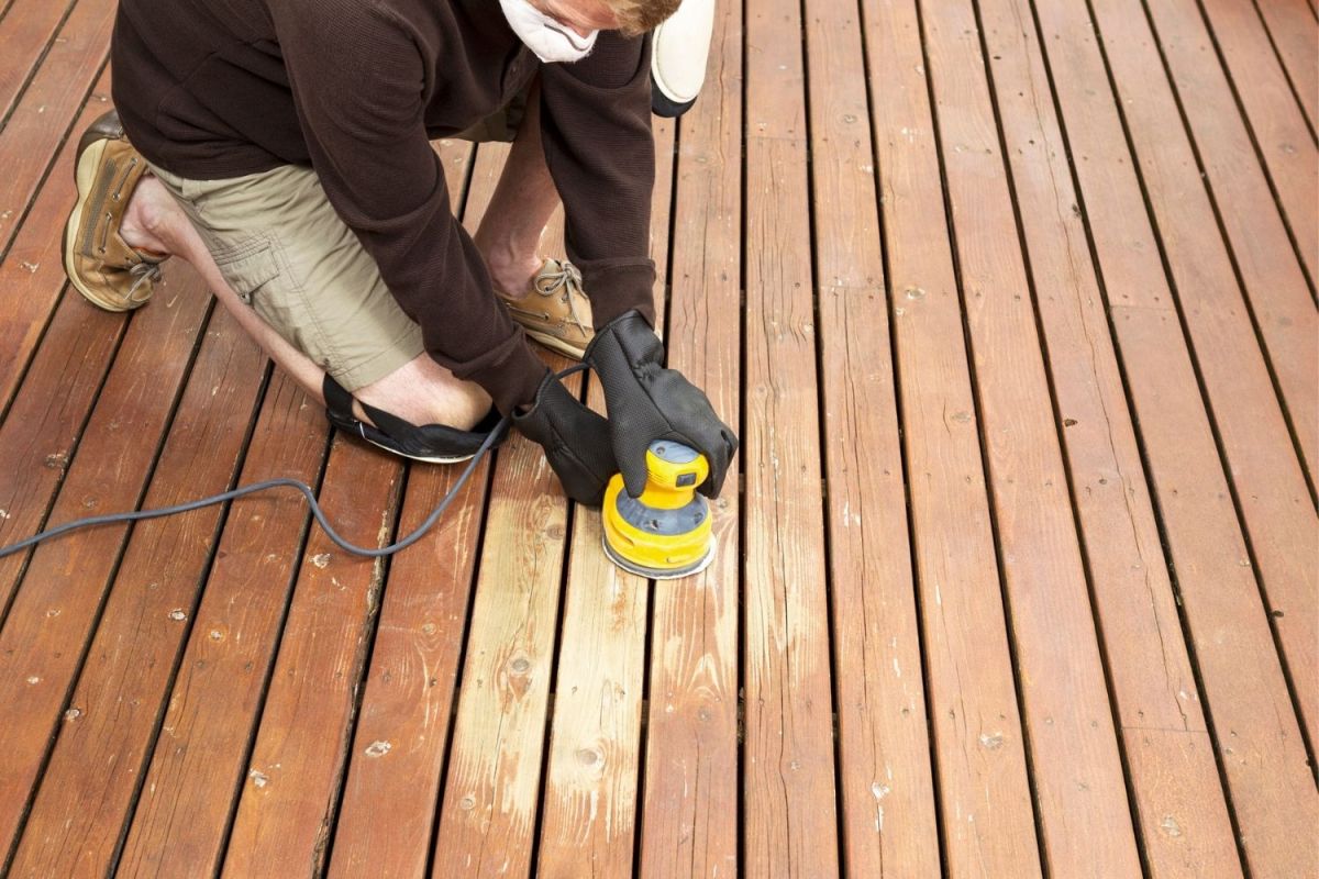 A close up of a person using a tool to repair a deck.