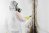 A worker in a white hazmat suit removes black mold on a wall.