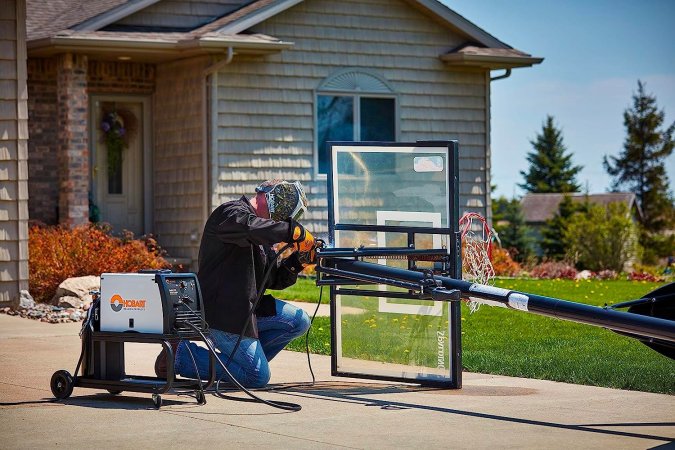 A person using the best welder for beginners option to weld a window frame