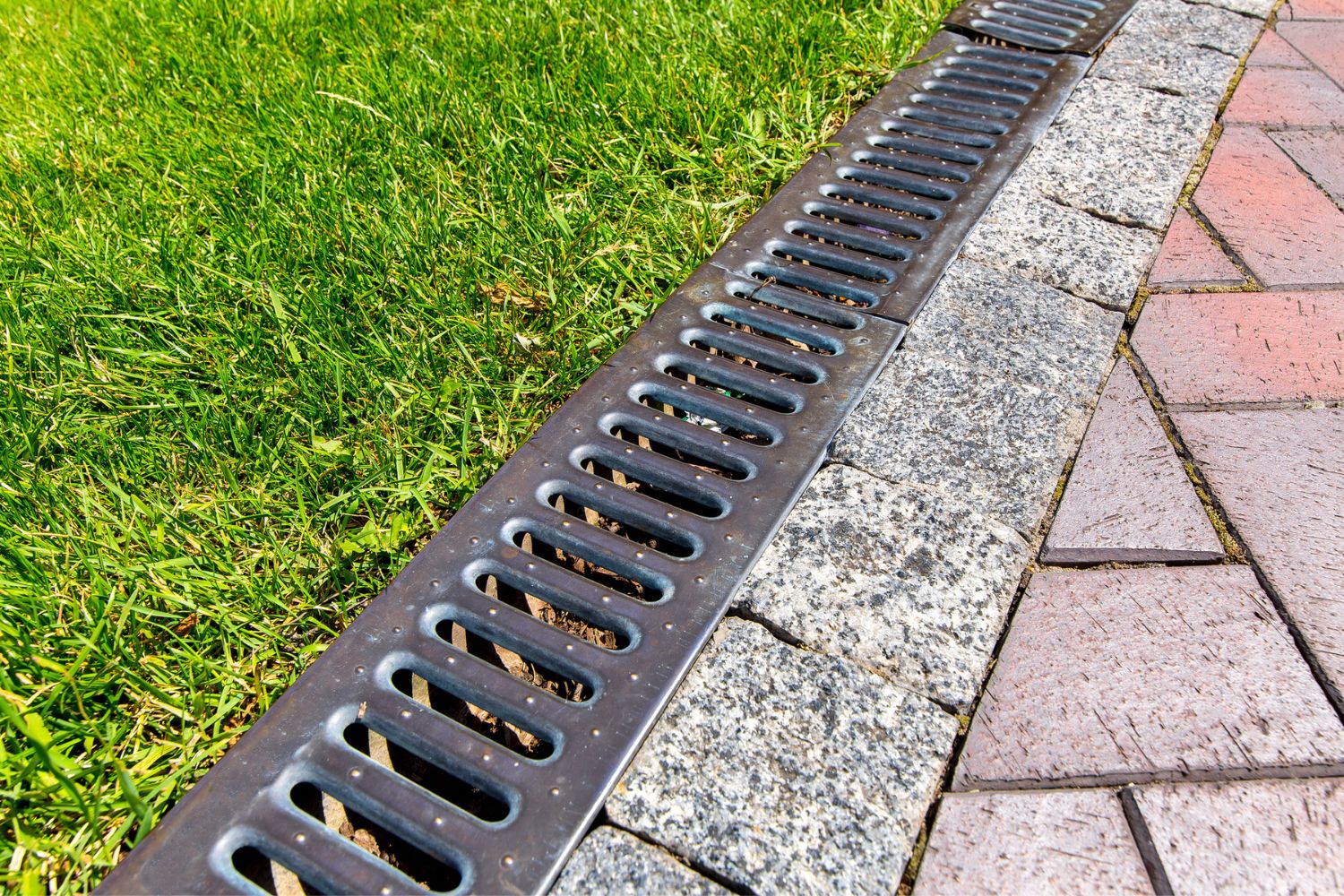 A close up of a drainage system lining a yard.