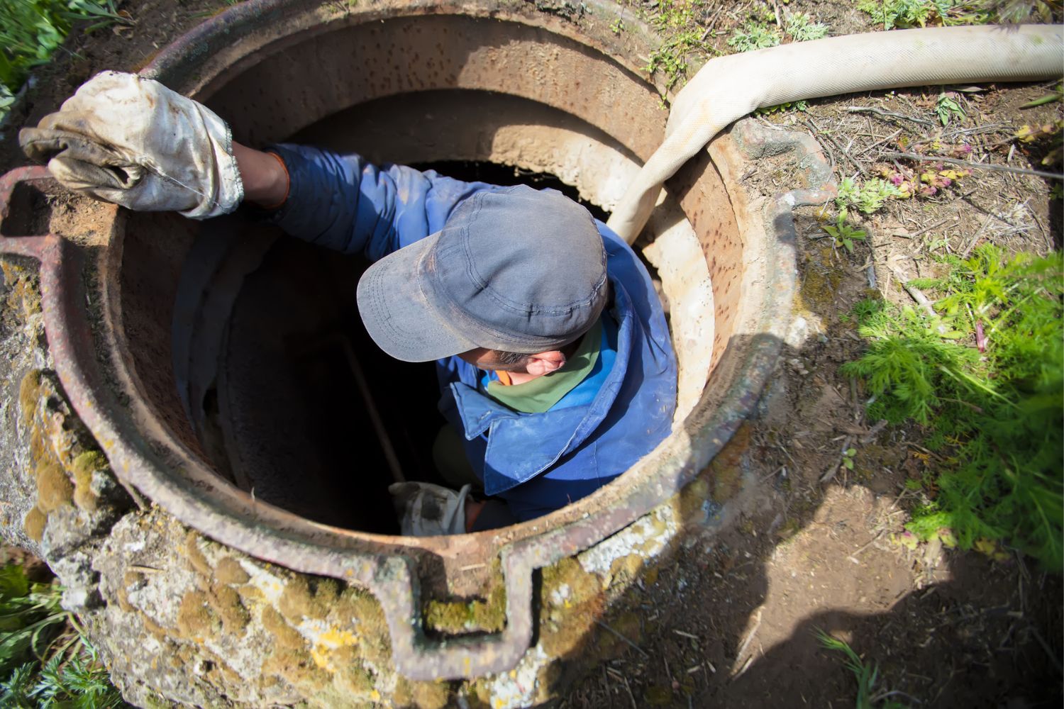 A worker descends into a large drain.