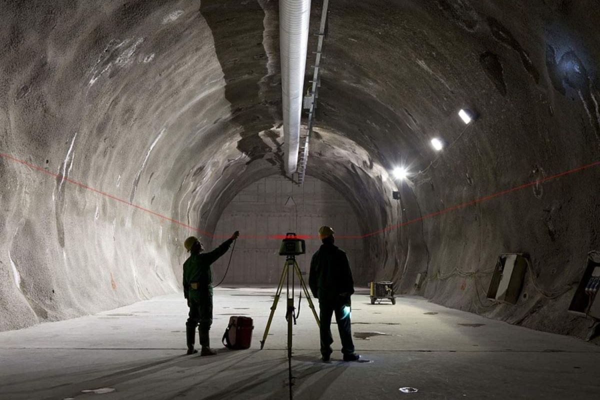 Two workers using the best rotary laser levels option in a tunnel