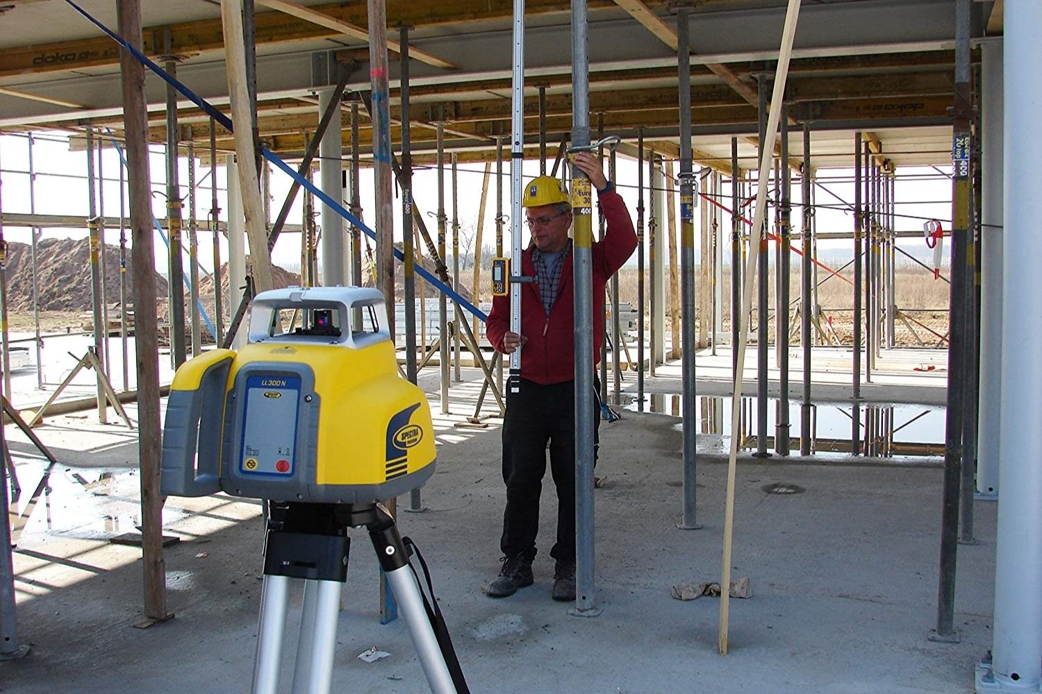 A construction worker using the best rotary laser levels option during framing of a building